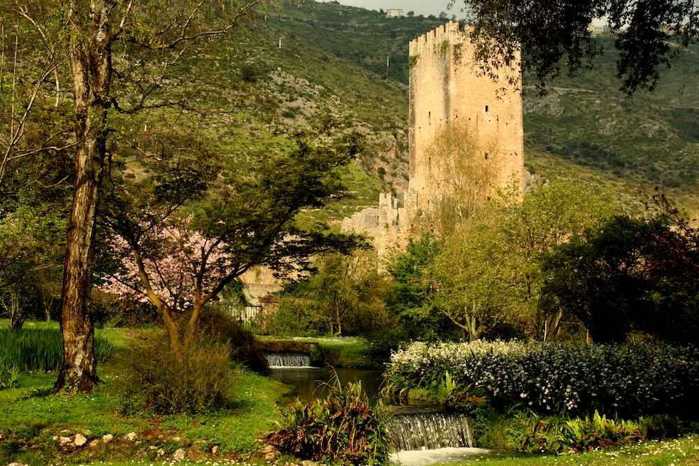 Panoramic view of the Garden of Ninfa with the river and ruins